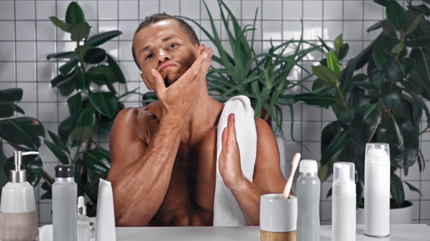 Uomo che applica il siero sulla barba in bagno - Filmati, video