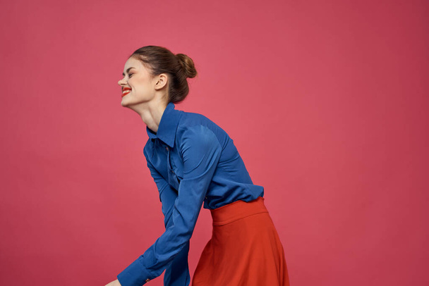 Vrouw in blauw shirt en rode blokjes op roze achtergrond leuke emoties model bijgesneden uitzicht - Foto, afbeelding