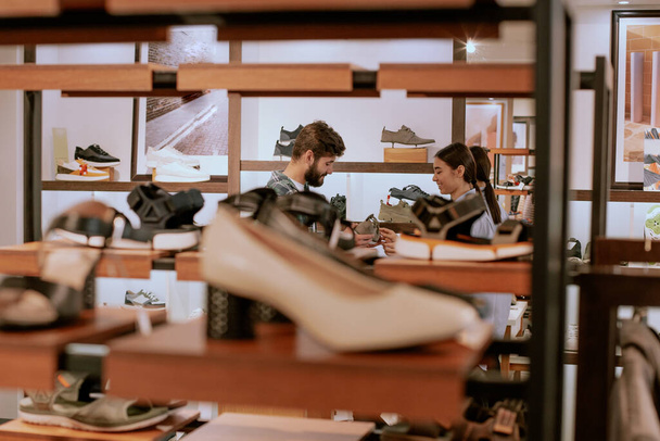 Podrobnosti prodávající dáma v obchodě s obuví diskutovat se zákazníkem o boty, které chce koupit - Fotografie, Obrázek