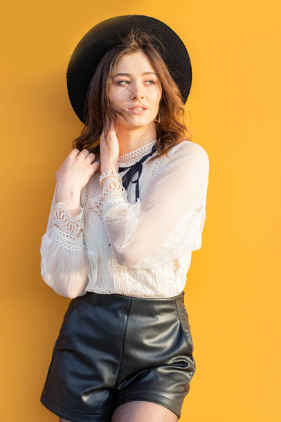 Miss with hat on a yellow background - Foto, imagen