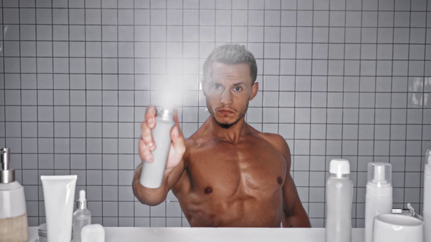 Hombre tomando desodorante y rociando a cámara - Metraje, vídeo