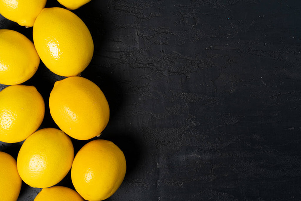 Top view of ripe lemon on black background - Foto, Imagen