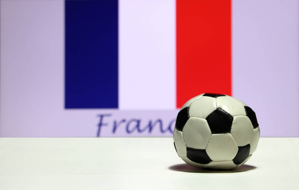 Маленький футбол на белом полу и из фокуса Tri Color или синий белый и красный цвет фона флага Франции с текстом Франча. Концепция спорта. - Фото, изображение