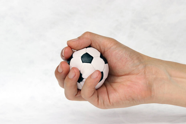 Mini labda a kezében a fehér háttér. Koncepciója sport vagy a játék fogantyú. - Fotó, kép