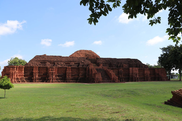 Ruiny kwadratowa baza magistralnej ceglanej stupy Khao Klang Nok na prawym boku, wplyw kultury Draravati, 8-9 stulecia naszej ery w Petchaboon, Tajlandia. - Zdjęcie, obraz