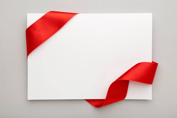 Close up of a note card with ribbon bow on grey background. Top view. - Foto, imagen