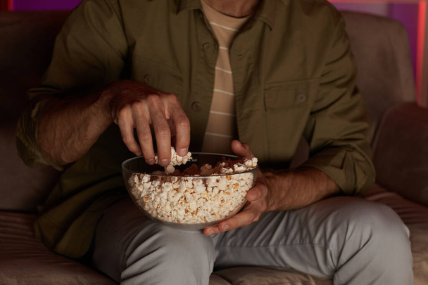 Man eating popcorn during watching - Фото, изображение