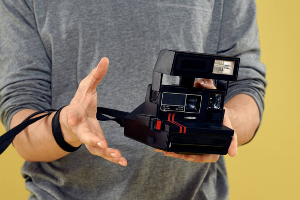Fotokamera in den Händen eines Mannes professionelle Ausrüstung Hobby Kreativer Ansatz Studio abgeschnittene Ansicht - Foto, Bild