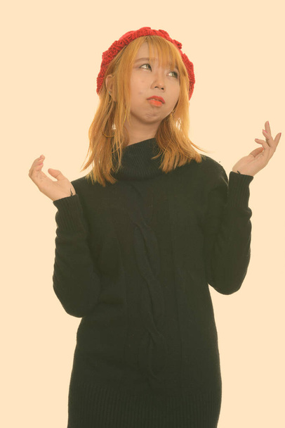 Studio shot of young Asian woman with dyed blond hair isolated against white background - Photo, Image