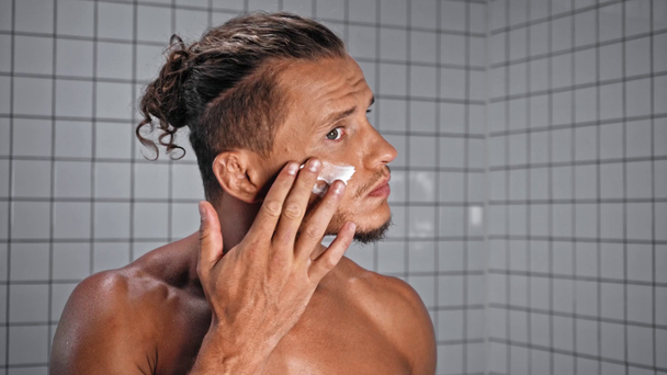 Man aanbrengen gezichtscrème in de badkamer - Video