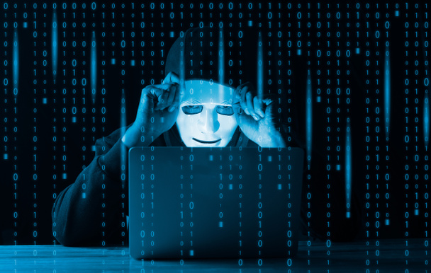Hacker e conceito de malware. Homem hacker com capuz perigoso usando laptop com interface digital de código binário. - Foto, Imagem