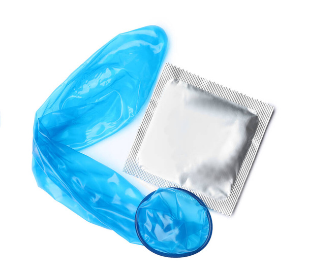 Unrolled blue condom and package on white background, top view. Safe sex - Photo, image