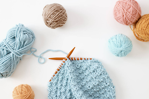 Knitting project in progress. A piece of knitting with ball of yarn and a knitting needles. - Fotoğraf, Görsel