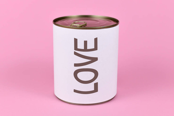 Love concept with large can and label saying 'LOVE' on pink background - Fotó, kép