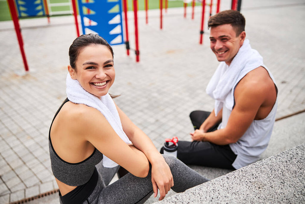 Щаслива молода пара розслабляється після тренування на спортивному майданчику
 - Фото, зображення