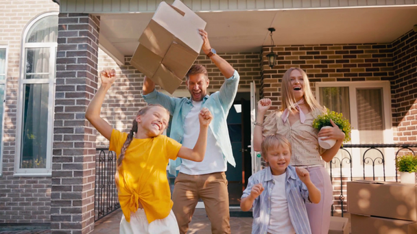 joyeuse danse familiale près des boîtes et de la maison de taille  - Séquence, vidéo