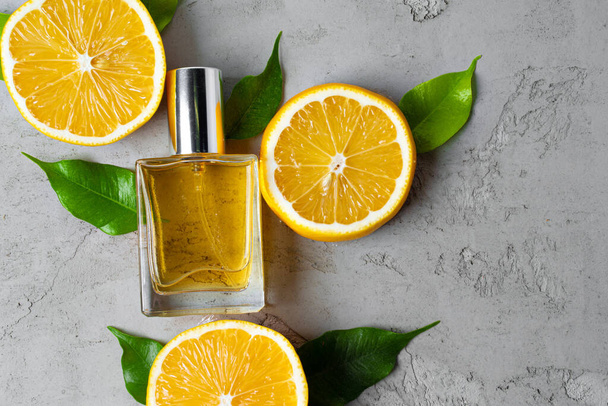 Beautiful composition with bottle of perfume and citrus fruits - Foto, afbeelding