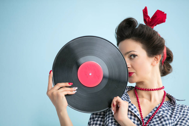 Retro vrouw in jaren vijftig stijl heeft een muzikaal record. - Foto, afbeelding