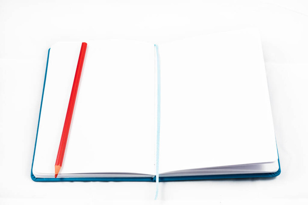 vista dall'alto di un quaderno aperto per prendere appunti con matita rossa su sfondo bianco. concetto di design - Foto, immagini