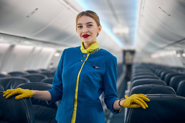 Glücklich lächelnde Stewardess im Anzug lächelt in die Fotokamera - Foto, Bild