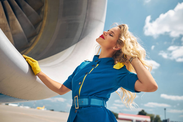 Прекрасная стюардесса, стоящая у самолета на аэродроме - Фото, изображение