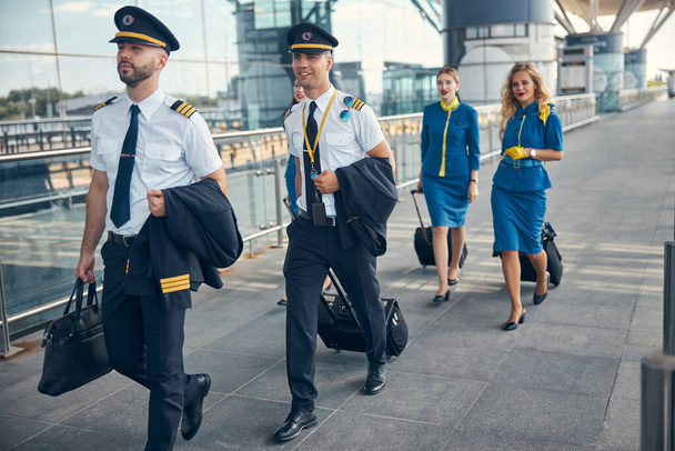 Экипаж с туристическими чемоданами шагает по улице - Фото, изображение