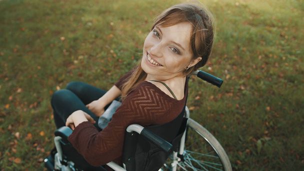Красивая кавказка-инвалид, смотрящая через плечо в парке - Фото, изображение