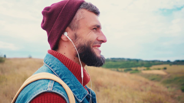 Zijaanzicht van de reiziger luisteren naar muziek, staan op de heuvel - Video