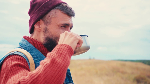 Oldalnézet utazó iszik teát termoszból kívül - Felvétel, videó