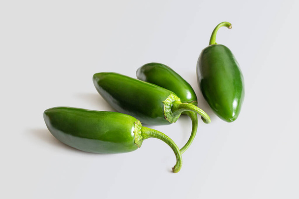 Λαμπερό πράσινο λοβό από ζεστό, μεξικάνικο πιπέρι jalapeno, σε ανοιχτό γκρι φόντο - Φωτογραφία, εικόνα