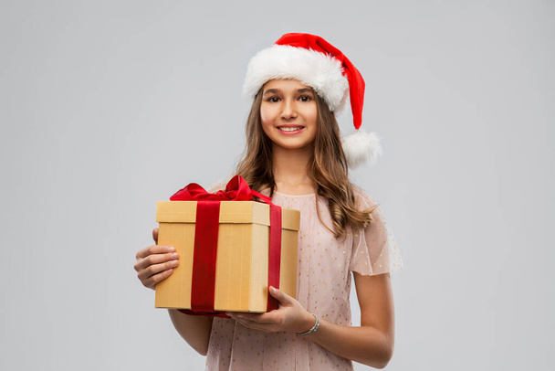 teenage girl in santa hat with christmas gift - Fotoğraf, Görsel