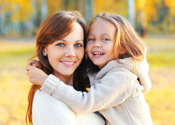 Autumn portrait of happy smiling mother with her daughter child in the park - Fotografie, Obrázek