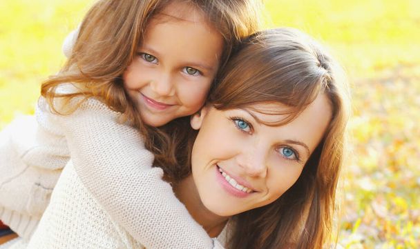 Autumn portrait of happy smiling mother with her daughter child in the park - Photo, image