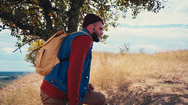 Вид збоку туриста з рюкзаком, що піднімається на пагорб
 - Кадри, відео