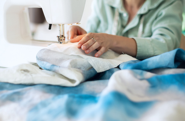 Chica trabajando con la máquina de coser. Proceso de costura - Las manos femeninas detrás de su costura - Foto, Imagen