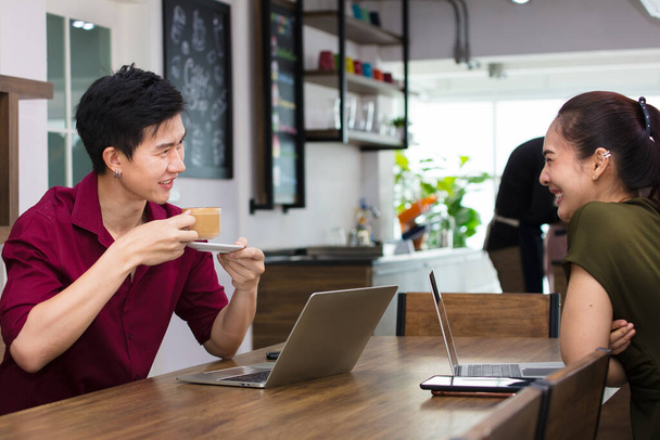 Azjatycki biznesmen burzy mózgów i dyskusji szczęśliwie w kawiarni. Czas wolny w przerwach obiadowych dla pracowników biurowych. - Zdjęcie, obraz