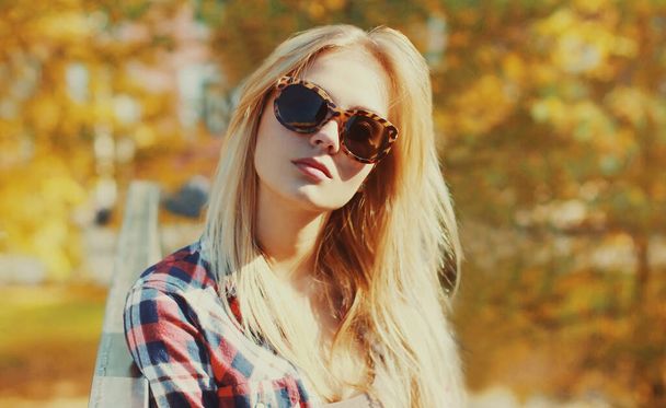 Close up portrait of beautiful young blonde woman in autumn park - Photo, image
