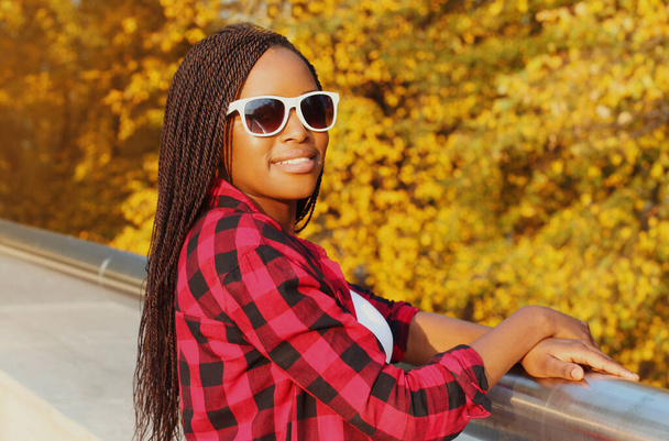 Portrait of young smiling african woman wearing sunglasses in autumn day - Zdjęcie, obraz