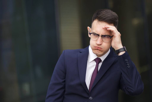 Tired dissatisfied angry businessman in suit and glasses. Frustrated offended young guy - Foto, immagini