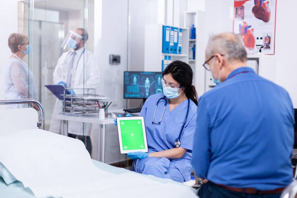Patient regardant la tablette avec écran vert - Photo, image