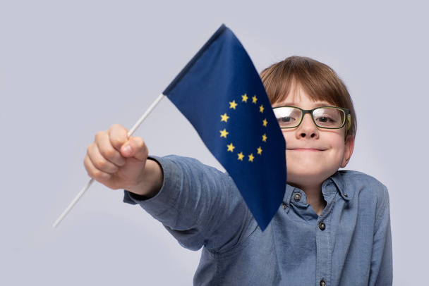 Ragazzo con gli occhiali con la bandiera dell'Unione europea. Chiudete. Studio in Europa. - Foto, immagini