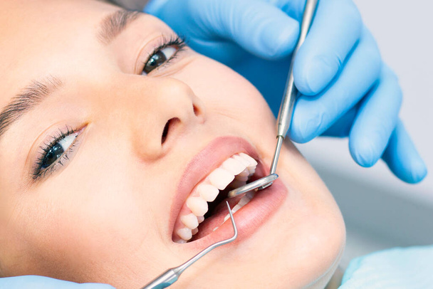 Giovane donna attraente in una clinica dentistica con un dentista maschio. Concetto denti sani. - Foto, immagini