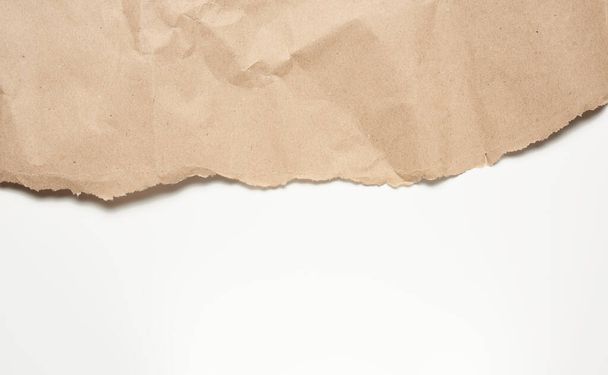 Beyaz arkaplan üzerine buruşuk kahverengi ambalaj kağıdı, tasarımcı için arkaplan, kopyalama alanı - Fotoğraf, Görsel