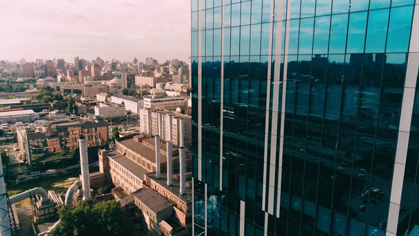 Letecký pohled na moderní mrakodrap v průmyslové čtvrti - Záběry, video