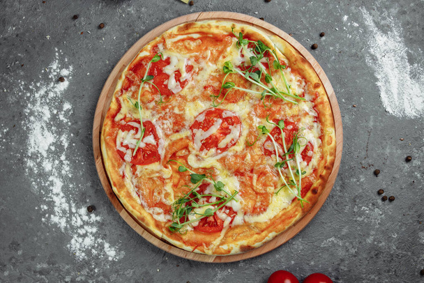 Pizza Margherita sur fond de pierre noire, vue sur le dessus. Pizza Margarita aux tomates, basilic et fromage mozzarella close up. - Photo, image