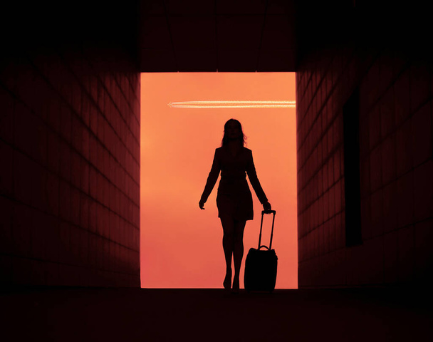 one business woman. silhouette of traveler. Female  walking with suitcase.  front view. isolated on sky background. Plane fly in sky. - Фото, зображення