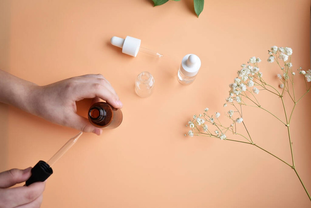 Cosmetic oil with a pipette in hand on a natural background. - Fotografie, Obrázek