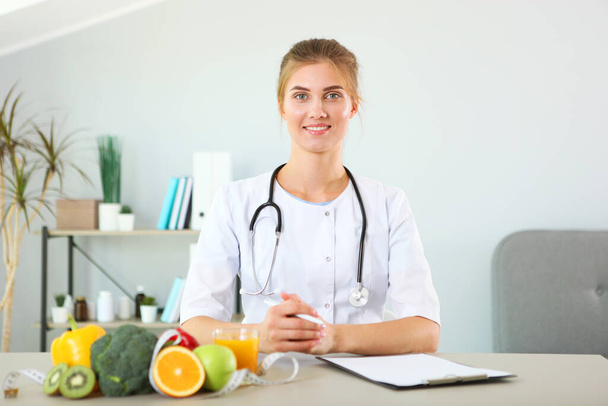 joven médico nutricionista en su oficina demuestra el concepto de alimentación saludable. Ayuda con el control de peso - Foto, Imagen