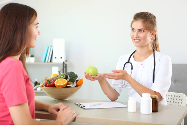 Dokter nutritionist neemt een patiënt mee naar kantoor. goede voeding, gewichtsbeheersing - Foto, afbeelding