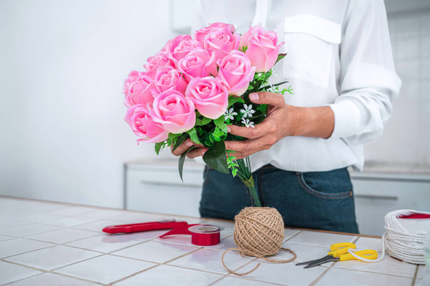 Arranging artificial flowers decoration at home, Young woman florist work making organizing diy artificial flower, craft and hand made concept. - Fotografie, Obrázek